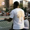 Rear view of a person wearing a white New York Knicks 2026 NBA Finals Championship Shirt at a basketball court.