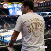 Back view of a man wearing a white New York Knicks 2026 NBA Finals Championship Shirt inside an arena.