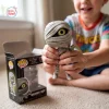 Close-up of a child holding the Mummy Boy vinyl figure next to its box.