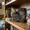 Front view of the Nightmare Before Christmas Mummy Boy vinyl figure standing next to its box on a wooden bookshelf.