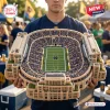 Front view of a person holding a detailed Notre Dame Fighting Irish Plush Stadium Pillow.