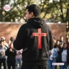 Back view of a person wearing an Ohio State Buckeyes Jesus Won black hoodie featuring a red cross and John 16:33 text.