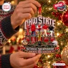 Closeup of hands holding a shaped Ohio State Buckeyes National Champions Christmas Ornament on a tree.