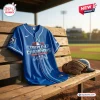 Front view of an Oklahoma City Comets 2026 blue baseball jersey displayed on a wooden bench.