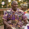 An older man wearing an Omega Psi Phi Purple Hawaiian Shirt outdoors.
