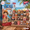 Front view of One Piece Advent Calendar 2026 packaging alongside twenty-four small anime character figures on wooden tiers.