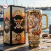 Front view of One Piece Luffy Gear 5 gold tumbler next to its matching box on a wooden table.