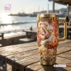 Front view of One Piece Luffy Gear 5 gold tumbler on a wooden table outdoors.