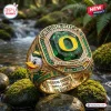 Closeup of the Oregon Ducks 132nd Anniversary 1894-2026 Ring resting on mossy river stones.