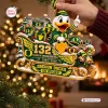 Closeup of Oregon Ducks 132nd Anniversary Sleigh Ornament held by hand near a lit tree.