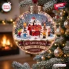 Close-up of a Peanuts 76th Anniversary glass Christmas ornament hanging on a pine tree.