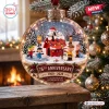 Closeup of Peanuts 76th Anniversary Glass Christmas Ornament hanging on a tree with character figures inside.