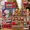 Front view of Peanuts Snoopy Christmas 2026 Advent Calendar box next to a tiered display of twenty-four character figures.
