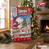 Front angle view of Peanuts Snoopy Christmas 2026 Advent Calendar box on a wooden table with pinecones.