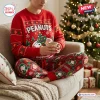 Front view of Peanuts Snoopy Christmas sweater and jogger pants set worn by a person holding a mug on a couch.