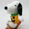 Side view of a Snoopy plush doll wearing an orange pumpkin costume with a green collar.