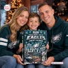A smiling family holding a Philadelphia Eagles 2026 Advent Calendar in front of a Christmas tree.