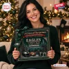 A woman holding a Philadelphia Eagles Christmas Advent Calendar in front of a lit tree.