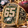 Closeup of a gold championship ring featuring the number 65, an eagle logo, and text commemorating Lane Johnson.