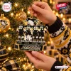 Close-up of hands holding a Pittsburgh Penguins 2025 Farewell Tour Ornament hanging on a Christmas tree.