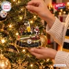 Close-up of hands hanging the Pittsburgh Steelers Santonio Holmes Toe-Tap Catch Christmas Ornament on a lit tree.