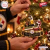 Close-up of hands hanging the Pittsburgh Steelers Santonio Holmes Toe-Tap Catch Christmas Ornament on a tree.