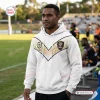 Man wearing PNG Chiefs Limited Edition White Hoodie standing on an athletic field.