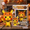 Front view of Pokémon Pikachu Christmas Vinyl Figure styled with a pumpkin head and black cape next to its box.