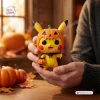 Close-up view of a yellow Pokémon Pikachu Christmas vinyl figure wearing a pumpkin hat and holding a candy bucket.