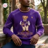 Front view of a purple sweatshirt featuring a bear graphic and text.