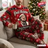 Man wearing red holiday sweater and plaid jogger pants set sitting on a couch near a Christmas tree.