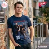 Man wearing a blue Powderfinger Rock Band 2027 Tour Limited Edition Shirt while leaning against a brick wall.