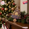 Close-up of a Queen Elizabeth II centenary commemorative Christmas ornament resting on a mantelpiece.