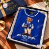 Top-down view of a blue sweatshirt featuring a bear graphic inside a gift box.