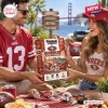 Lifestyle view of a couple holding a San Francisco 49ers mini helmet advent calendar outdoors.