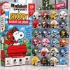 Front view of Riddell Snoopy Christmas Mini Helmet Advent Calendar packaging next to a display case of collectible mini helmets.