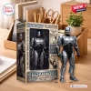 Front view of the Robocop 39th Anniversary Action Figure outside its commemorative packaging box on a wooden desk.