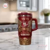 Front view of a red San Francisco 49ers 80th Anniversary stainless steel tumbler with handle on a marble kitchen counter.
