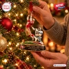 Close-up view of hands hanging a San Francisco 49ers Dwight Clark Christmas ornament on a lit tree.