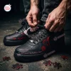 Close-up of a person tying the laces on Saw Horror Movie Spiral Air Force 1 Sneakers featuring red text and puzzle pieces.