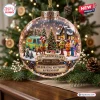 Front view of a clear globe ornament featuring a miniature winter scene with a van, Christmas tree, and characters.