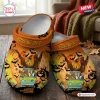 Angle view of orange Scooby Doo Halloween Crocs clogs shoes featuring a spooky mystery machine van graphic.