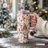 Hand holding a Snoopy Christmas Pink 40Oz Tumbler with winter holiday illustrations.
