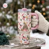 Hand holding a Snoopy Christmas Pink 40Oz Tumbler with holiday cartoon graphics outdoors in the snow.