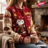 Front view of Snoopy Happiness Is A Warm Hug Varsity Jacket in red and cream worn by someone holding a mug.