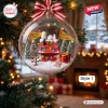 Close-up view of a clear ornament containing a red doghouse, miniature pine trees, and a Beagle figure.