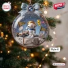 Closeup of Snoopy Happy Holidays Snow Globe Ornament hanging on tree with moon landing scene.