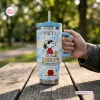 Hand holding Snoopy Joe Cool Handle Tumbler on outdoor wooden table.