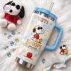 Angled view of a Snoopy Joe Cool Handle Tumbler with a blue lid and straw on a fluffy white rug.