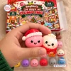 Closeup of a hand holding two holiday themed squishies in front of Sophia's Dumpling Squishy Christmas Advent Calendar.
